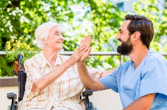 Senior high-fiving caregiver
